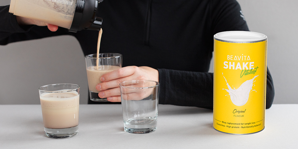 Personne verse boisson du shaker dans des verres. Boîte BEAVITA SHAKE Vital, Original.