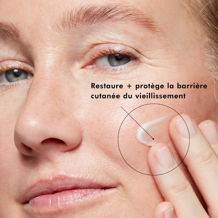 Femme appliquant de la crème. Texte : Restaure + protège la barrière cutanée du vieillissement.